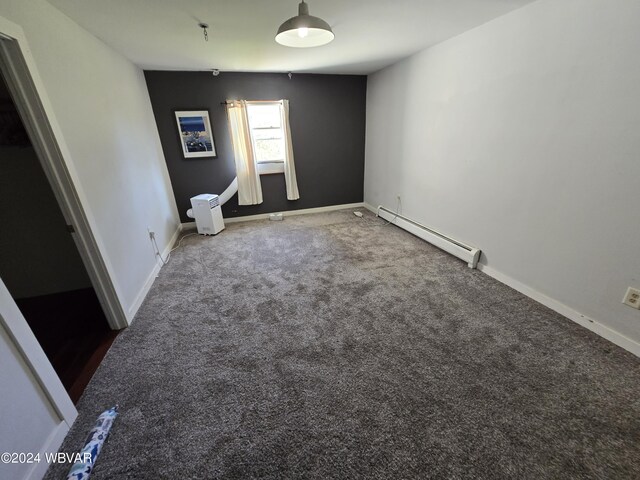 spare room with carpet and a baseboard heating unit