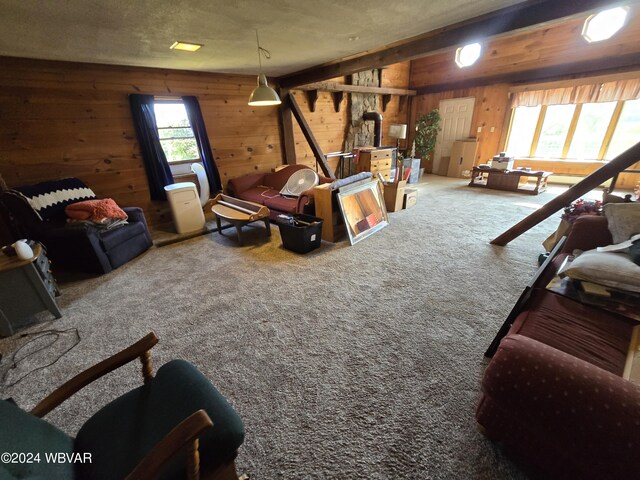 carpeted living room featuring wood walls and a textured ceiling