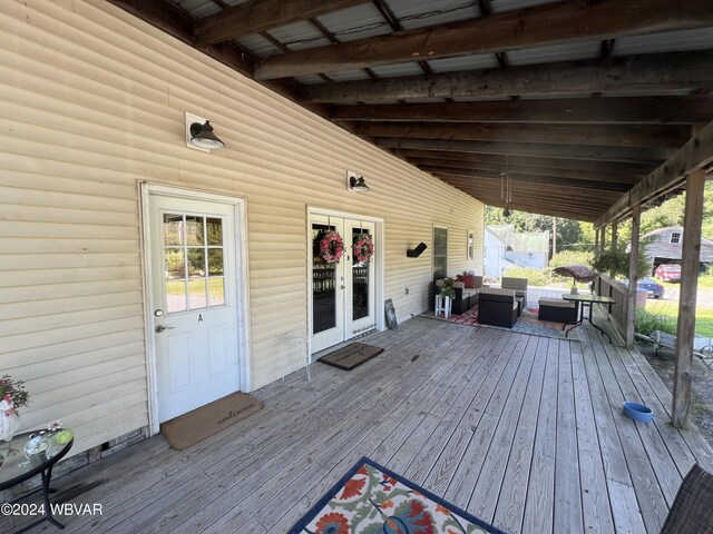 wooden deck with french doors and an outdoor hangout area