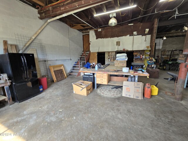 interior space featuring a workshop area and black fridge