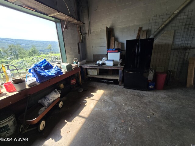 garage with black refrigerator and a workshop area