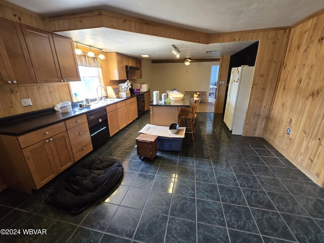 kitchen with sink, ceiling fan, wooden walls, and black appliances