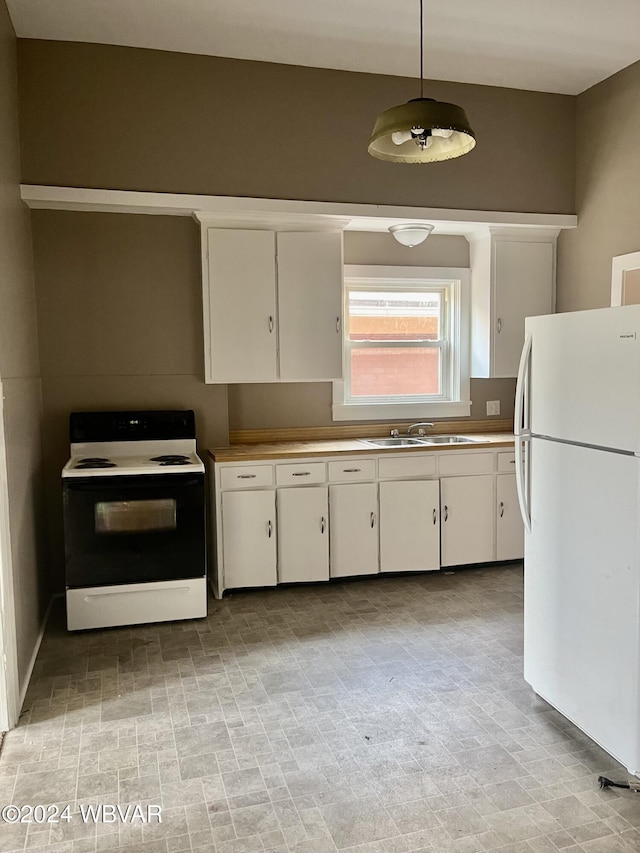 kitchen featuring white appliances, white cabinets, a sink, and decorative light fixtures