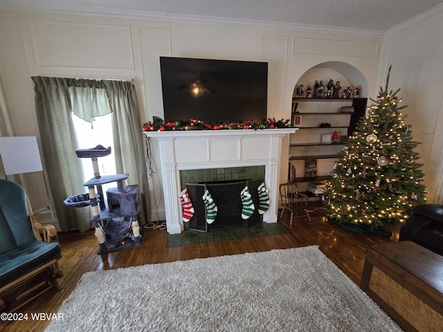 living room featuring a tile fireplace, crown molding, and dark wood-type flooring