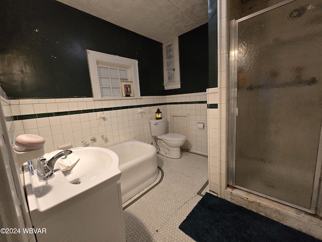 bathroom featuring tile patterned floors, a shower with shower door, and tile walls