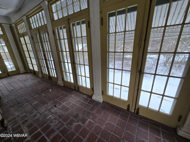 entryway with french doors, decorative columns, and a healthy amount of sunlight