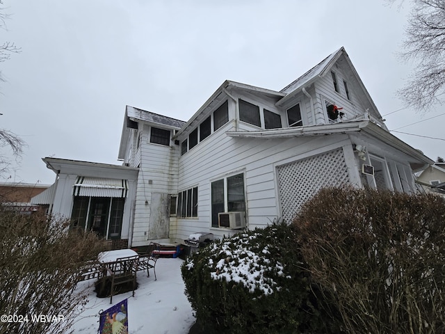 snow covered back of property featuring cooling unit