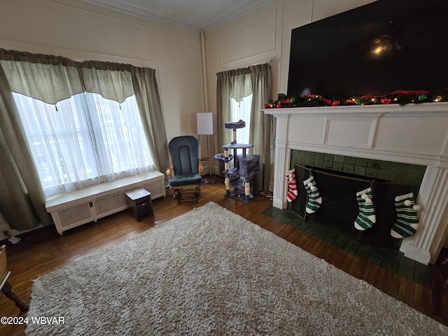 sitting room featuring dark hardwood / wood-style floors, ornamental molding, radiator heating unit, and a tile fireplace