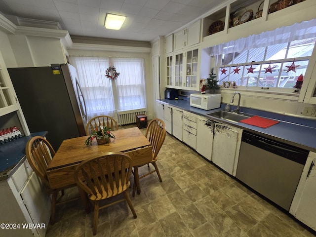 kitchen featuring dishwasher, white cabinets, crown molding, sink, and radiator heating unit