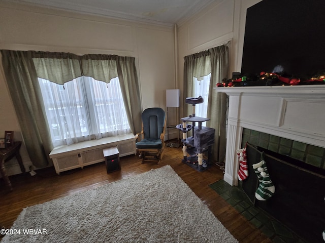 sitting room with a tiled fireplace, radiator heating unit, dark hardwood / wood-style flooring, and ornamental molding