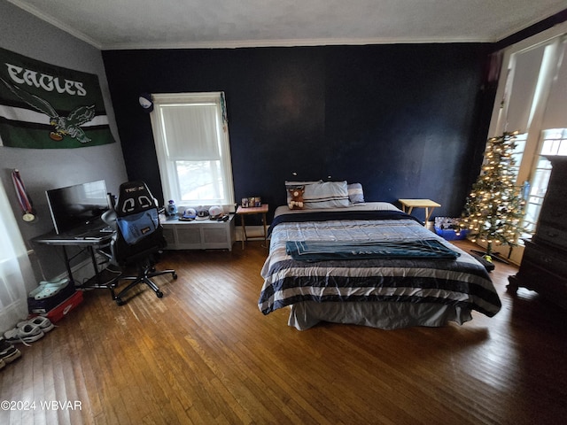 bedroom with crown molding and hardwood / wood-style floors