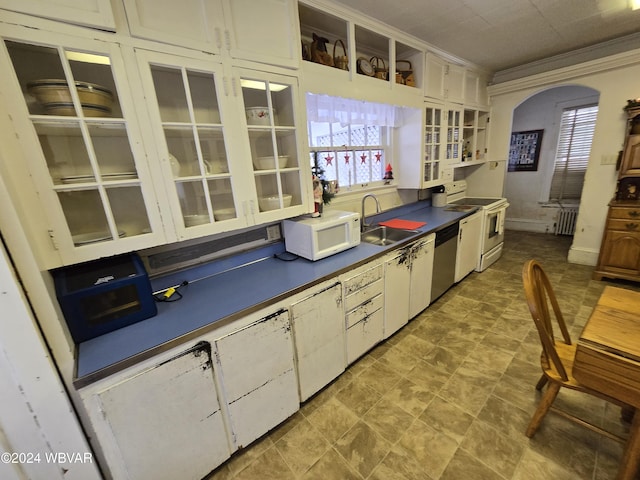 kitchen with white cabinets, appliances with stainless steel finishes, radiator heating unit, and sink