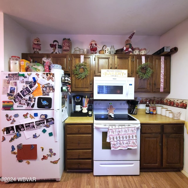 kitchen featuring white appliances and light hardwood / wood-style floors