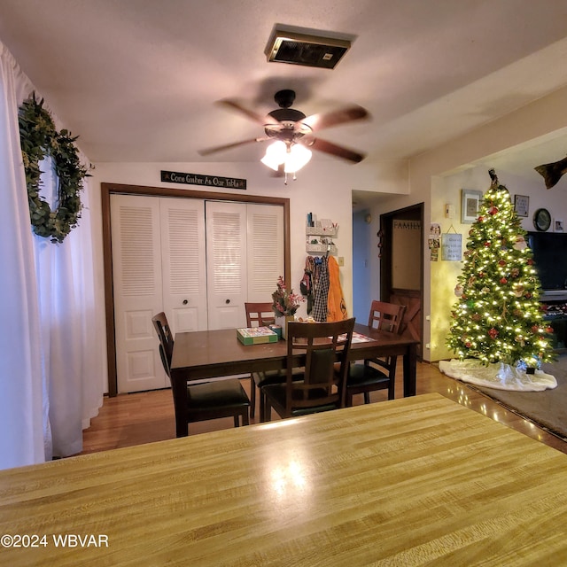 dining space with ceiling fan and wood-type flooring