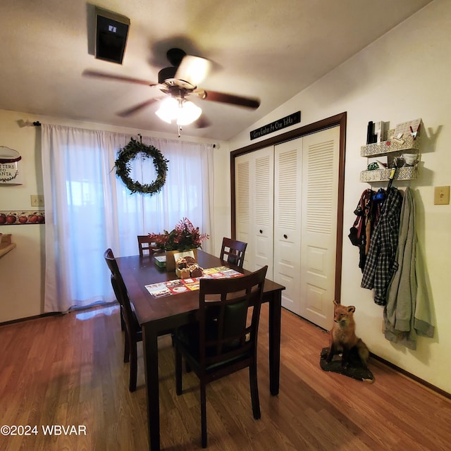 dining space with ceiling fan, wood-type flooring, and lofted ceiling