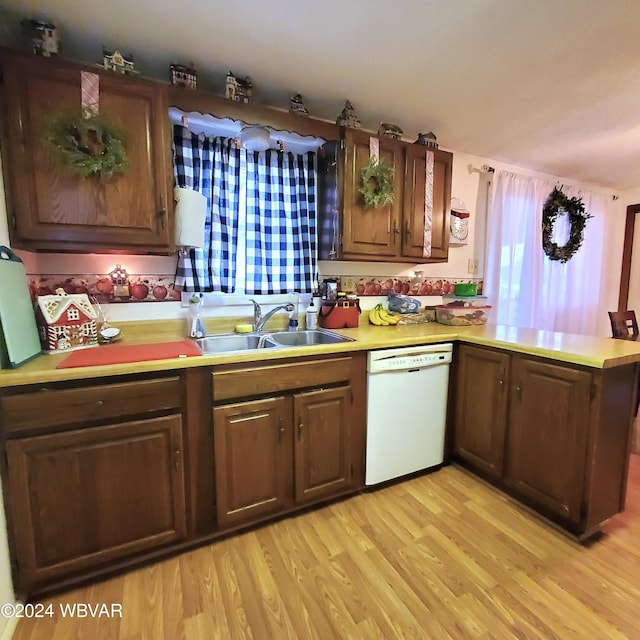 kitchen featuring kitchen peninsula, light wood-type flooring, white dishwasher, and sink