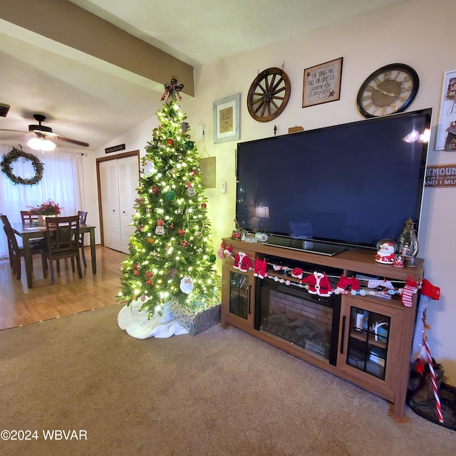 living room with hardwood / wood-style floors, ceiling fan, and lofted ceiling