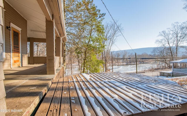 snow covered deck with a mountain view