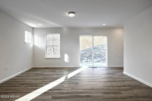 empty room with dark hardwood / wood-style flooring