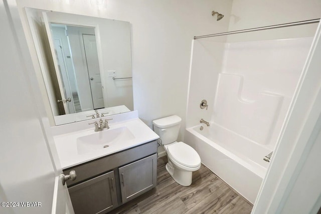 full bathroom with washtub / shower combination, wood-type flooring, vanity, and toilet