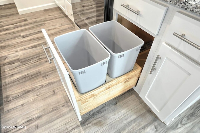 details featuring light stone counters, white cabinets, and light hardwood / wood-style floors