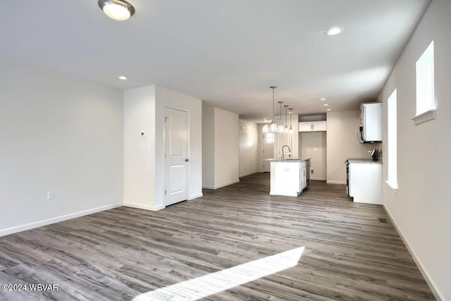 unfurnished living room with sink and hardwood / wood-style floors