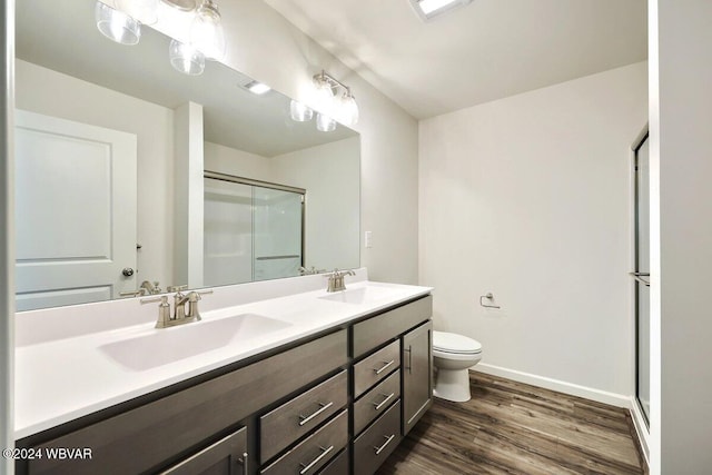 bathroom featuring vanity, hardwood / wood-style flooring, toilet, and an enclosed shower