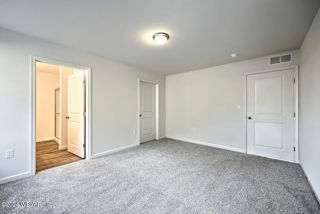 unfurnished bedroom featuring carpet flooring and ensuite bath