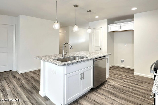 kitchen featuring sink, white cabinets, and an island with sink