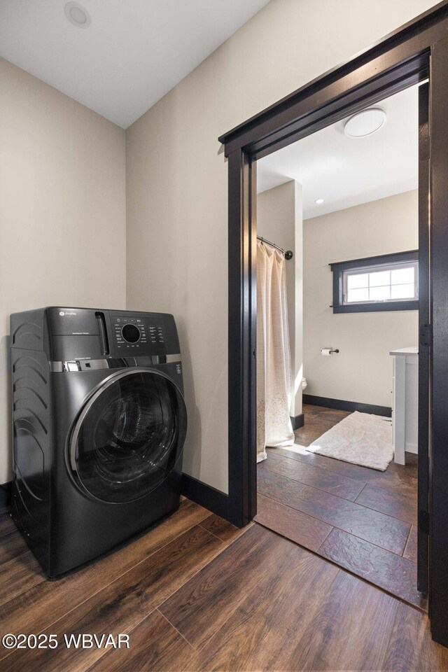 washroom with laundry area, washer / dryer, baseboards, and wood finished floors