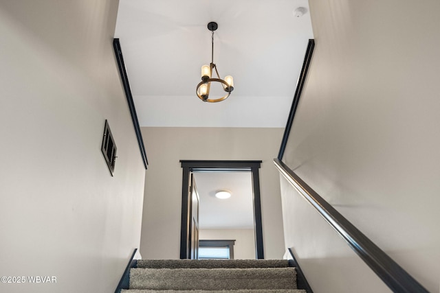 stairs with a notable chandelier