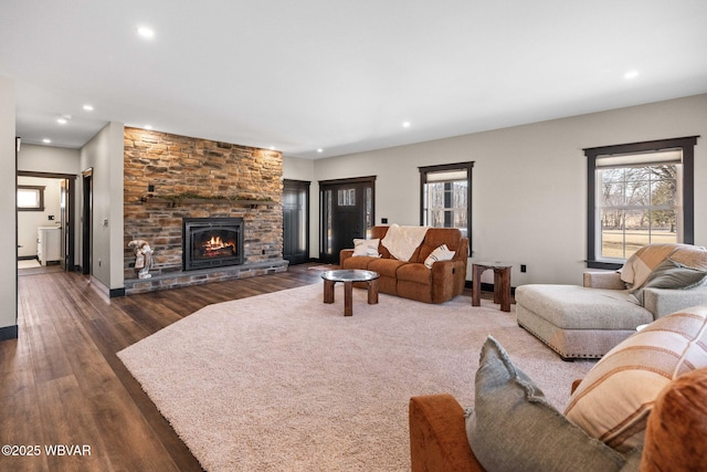 living room with dark wood-style floors, recessed lighting, a healthy amount of sunlight, and a fireplace