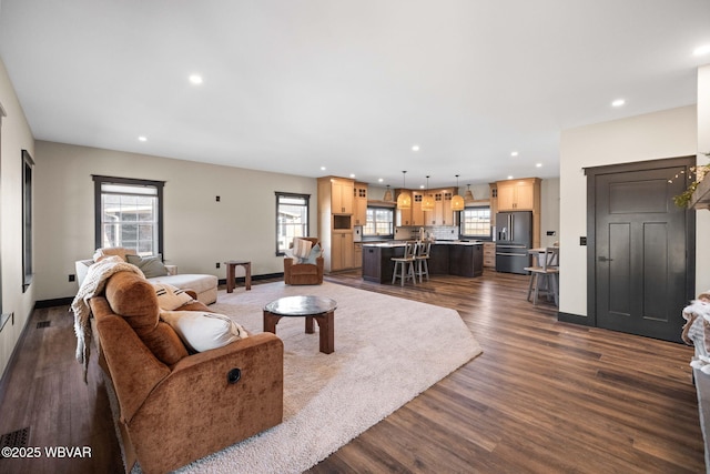 living area with recessed lighting, dark wood-style flooring, and baseboards