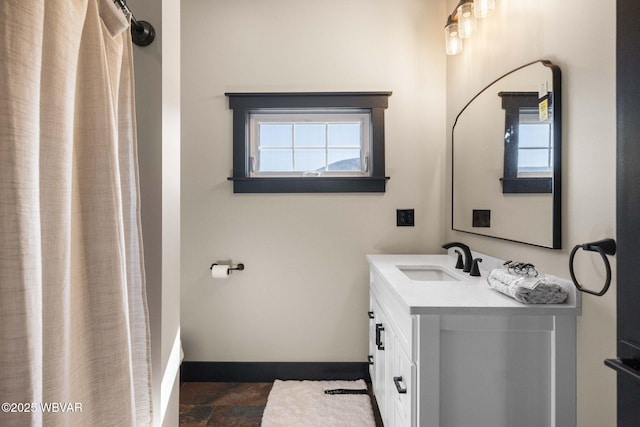 full bath featuring vanity, a shower with curtain, baseboards, and a wealth of natural light