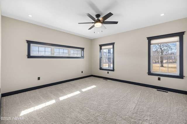 empty room featuring visible vents, baseboards, carpet, and a ceiling fan