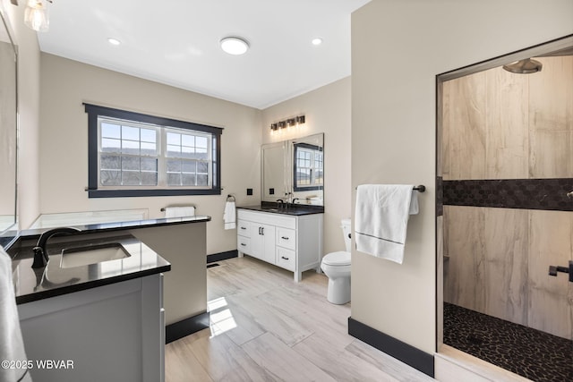 bathroom featuring two vanities, a walk in shower, and a sink