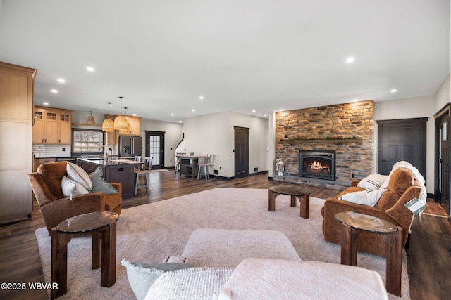 living room with dark wood finished floors, recessed lighting, and a fireplace