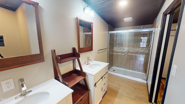 bathroom with wood-type flooring, vanity, and a shower with door