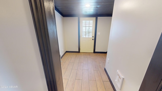 doorway featuring light wood-type flooring and wooden ceiling