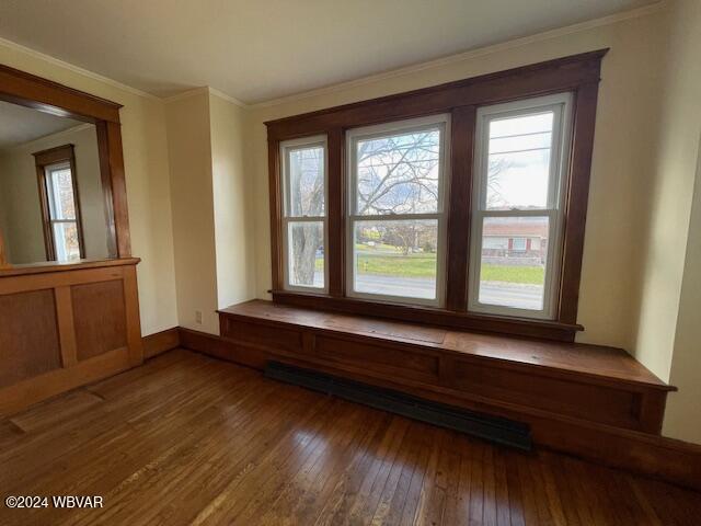 unfurnished room featuring ornamental molding, dark wood-type flooring, and baseboard heating