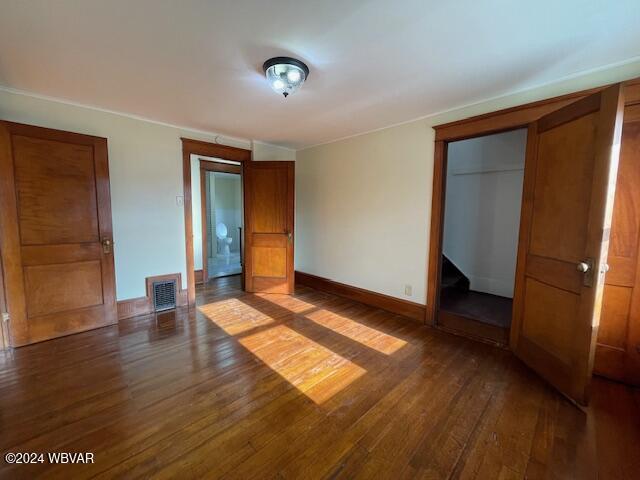 unfurnished bedroom with dark hardwood / wood-style floors