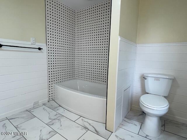 bathroom with washtub / shower combination and toilet