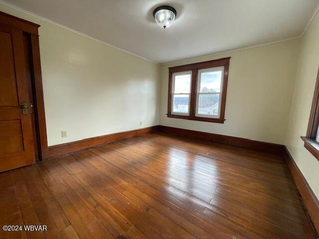 unfurnished room featuring dark hardwood / wood-style flooring and ornamental molding