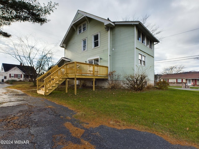 back of property featuring a yard and a wooden deck