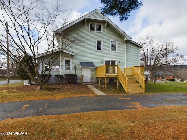 view of front of property with a front yard and a wooden deck