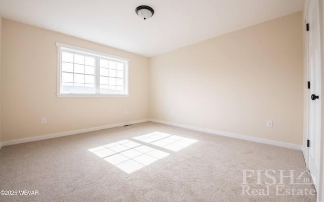 empty room featuring baseboards and light colored carpet