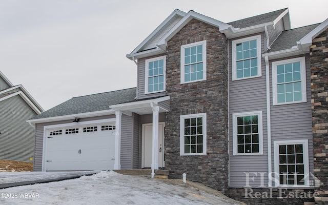 view of front of house with a garage and a shingled roof