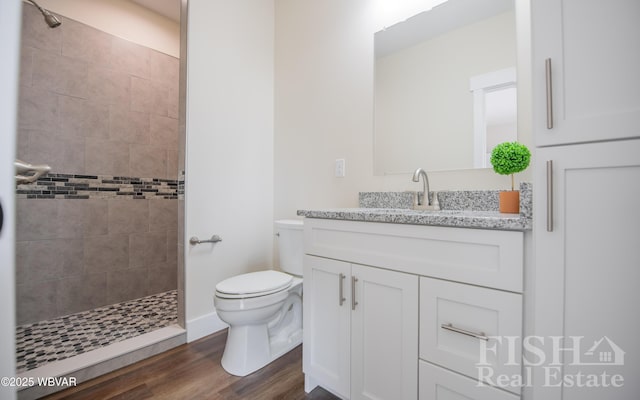 full bathroom with a walk in shower, vanity, toilet, and wood finished floors