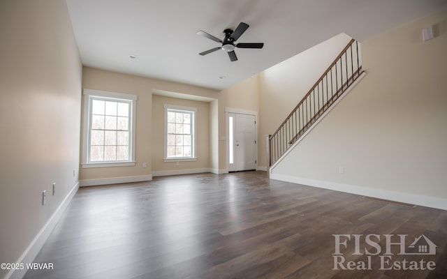 unfurnished living room featuring stairs, dark wood finished floors, and baseboards