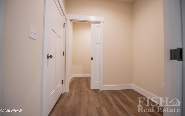 corridor featuring dark wood-style floors and baseboards